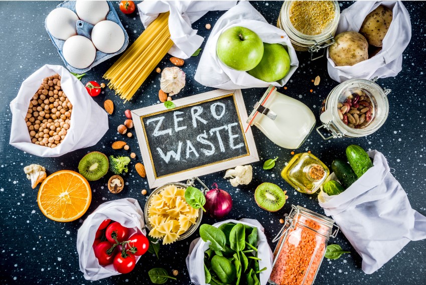A chalkboard reading "Zero Waste" surrounded by fresh food